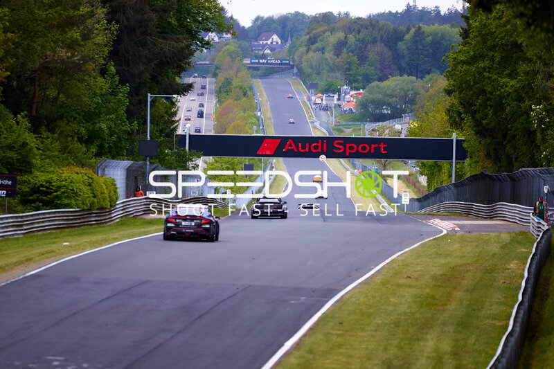 Mehrere Fahrzeuge auf der Nürburgring-Grand-Prix-Strecke unter Audi-Sport-Brücke