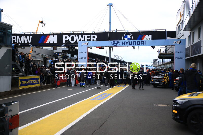 Boxengasse beim ADAC RAVENOL 24h Nürburgring mit Zuschauern und Sponsorenbanden