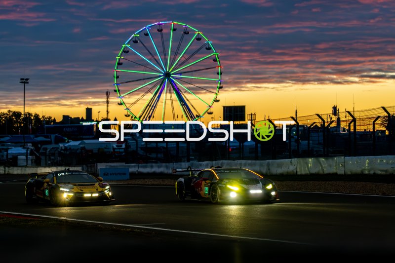 Nachtszene am Nürburgring: Drei GT3-Fahrzeuge vor beleuchtetem Riesenrad