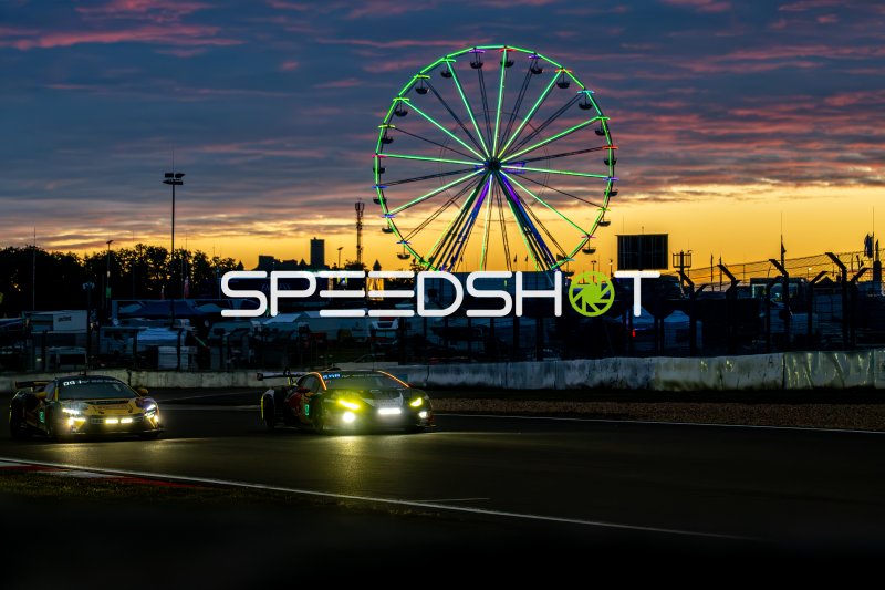 Zwei GT3-Fahrzeuge bei Sonnenuntergang am Nürburgring mit Riesenrad
