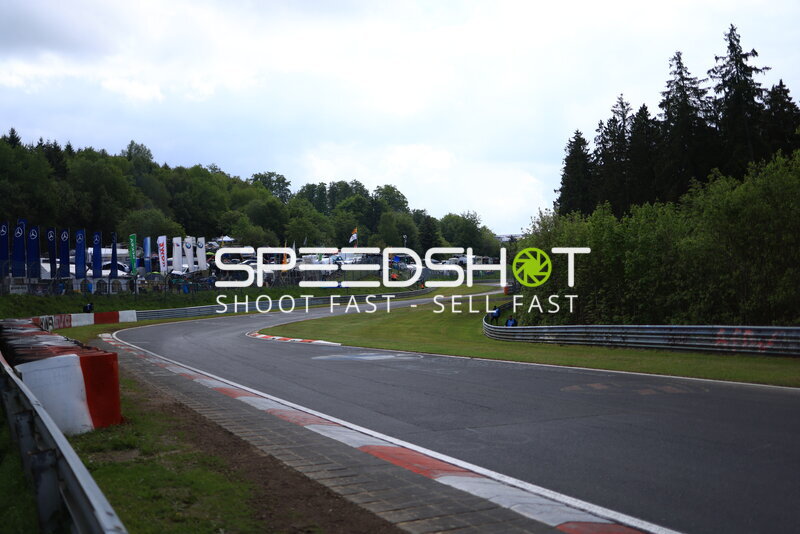 Leere Rennstrecke am Nürburgring mit Fahrerlager im Hintergrund