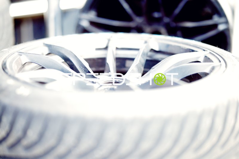 Nahaufnahme eines Motorsport-Leichtmetallrads mit Rennreifen