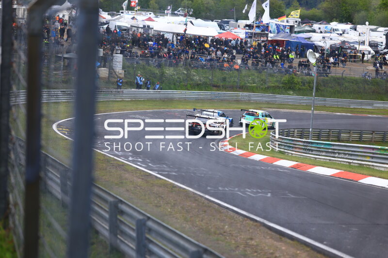 Drei Fahrzeuge kämpfen in der Kurve am Nürburgring