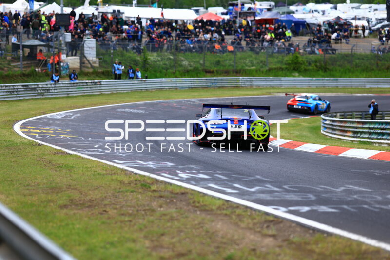 Blauer GT3-Rennwagen in der Kurve am Nürburgring mit H&R-Sponsoring