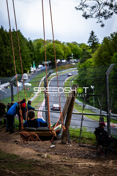 Fan auf Schaukel beobachtet das Renngeschehen an der Nordschleife