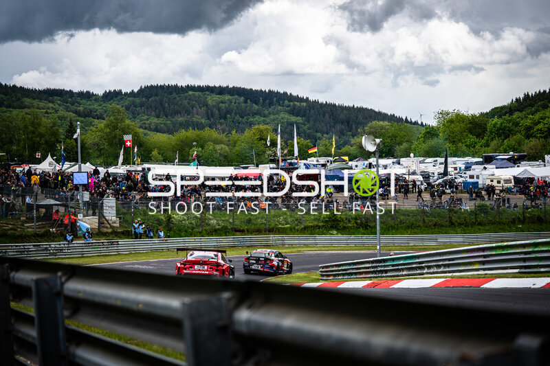 Zwei GT-Fahrzeuge in der Kurve auf der Nordschleife vor begeisterten Zuschauern