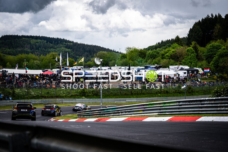 Mehrere Fahrzeuge in der Kurve auf der Nordschleife vor begeisterten Zuschauern