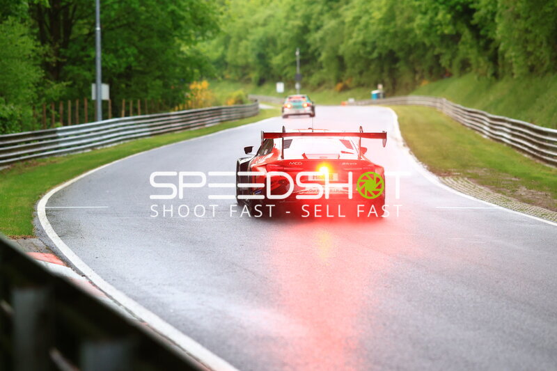 Roter GT3-Rennwagen auf nasser Nordschleife im Regen