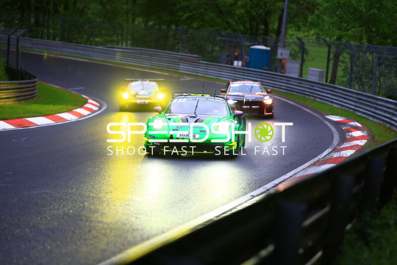 Grüner Porsche 911 GT3 führt Gruppe bei Regen auf der Nordschleife