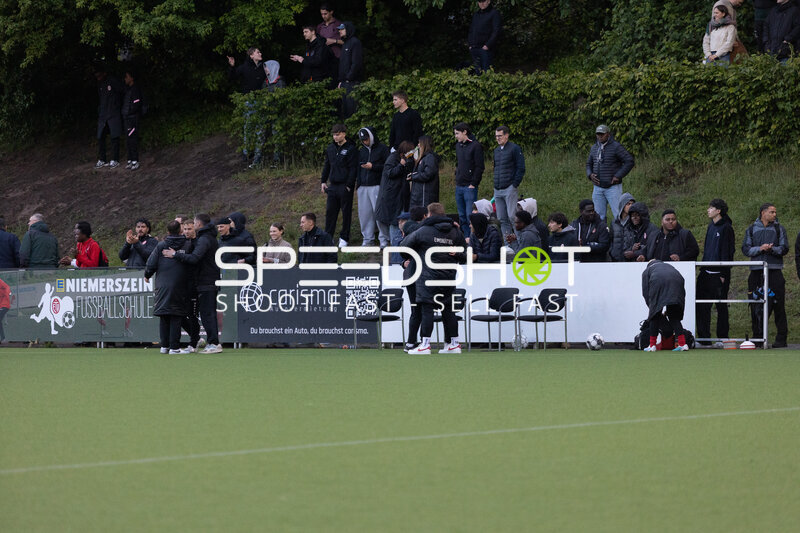 Fans und Teammitglieder am Spielfeldrand