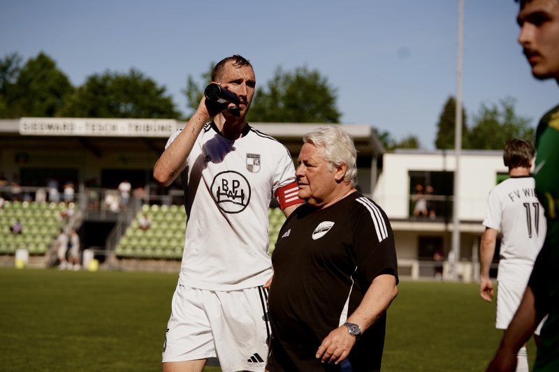 FV Wiehl Spieler trinkt in Spielpause neben Betreuer
