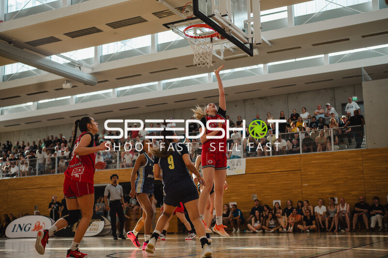 Basketballspielerin in rotem Trikot bei Würfen zum Korb
