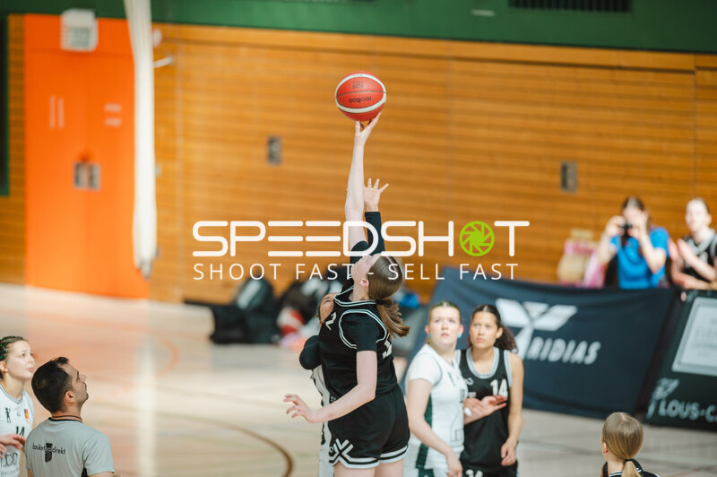 Spielerin wirft Basketball aus der Distanz in Stuttgarter Sporthalle