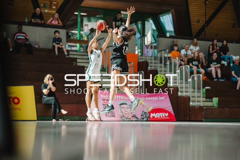 Basketballspielerin (#12) wirft gegen Defensivspielerin in Stuttgart