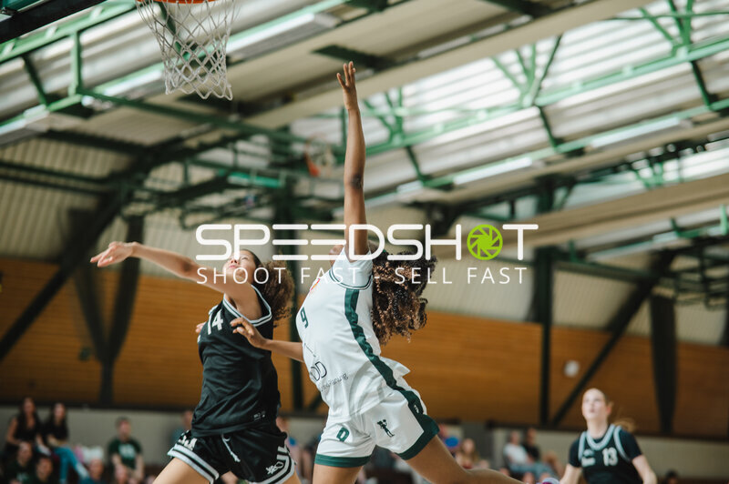 Basketballspielerin im Wurf gegen Verteidigerin