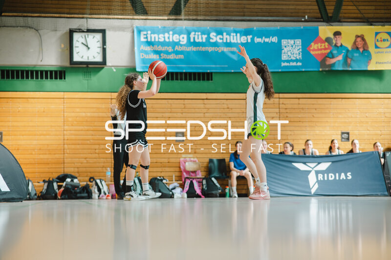 Basketballspielerin im Wurf gegen Defensivspielerin