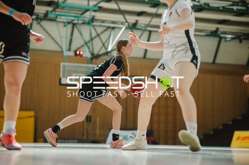 Spielerin im schwarzen Trikot beim Dribbling gegen Gegnerin in Weiß