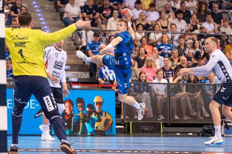 TVB Stuttgart Spieler springt zum Wurf gegen Benjamin Buric (#1; SG Flensburg-Handewitt)