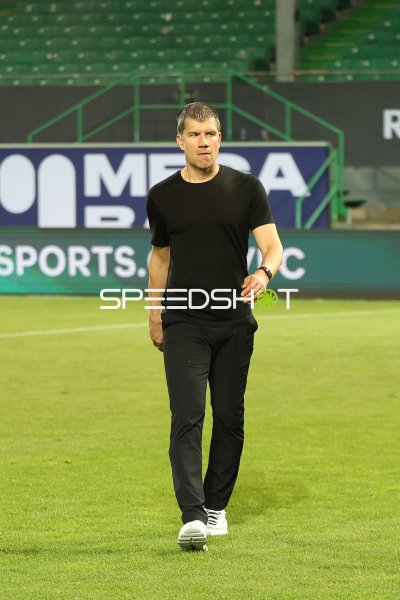Trainer läuft über den Rasen im Stadion