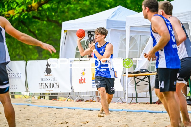 Spieler (#68) beim Wurfansatz im Beach-Handball