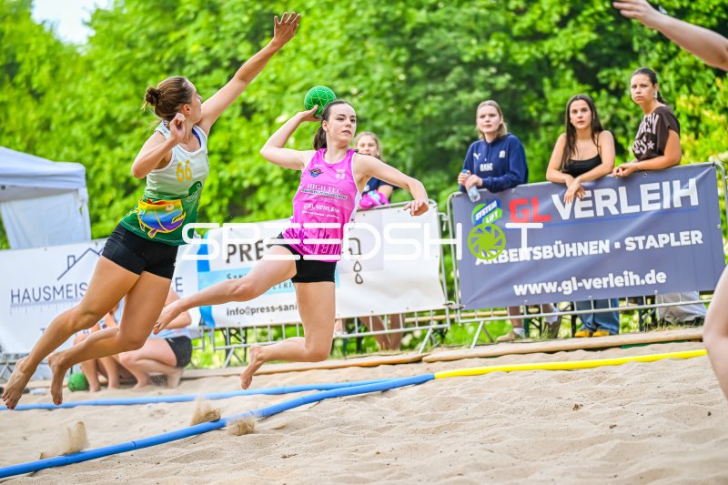 Spielerin (#93; Pink) beim Wurfversuch gegen Abwehrspielerin (#66) im Beach-Handball