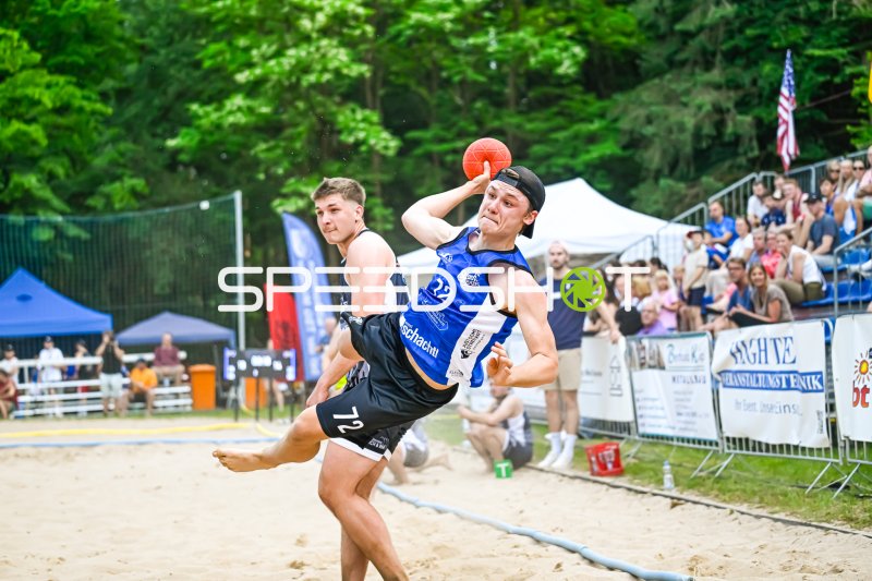 Spieler (#22) beim Wurfversuch im Beachhandball-Match