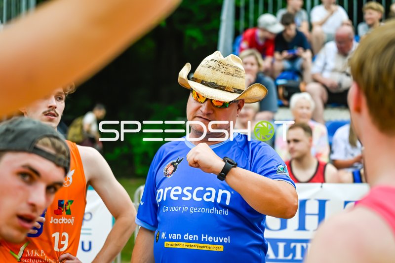Trainer mit Cowboyhut gibt Anweisungen am Spielfeldrand