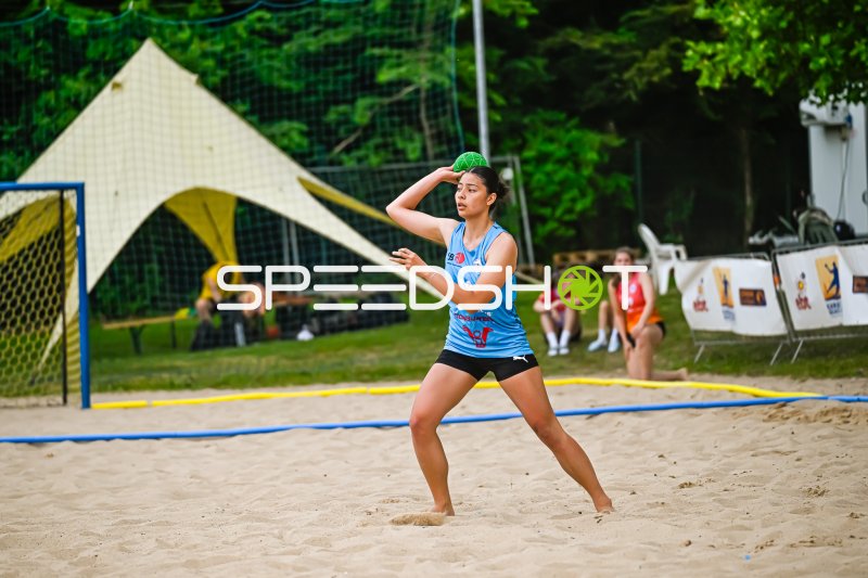 Spielerin im hellblauen Trikot beim Wurfansatz im Beach-Handball
