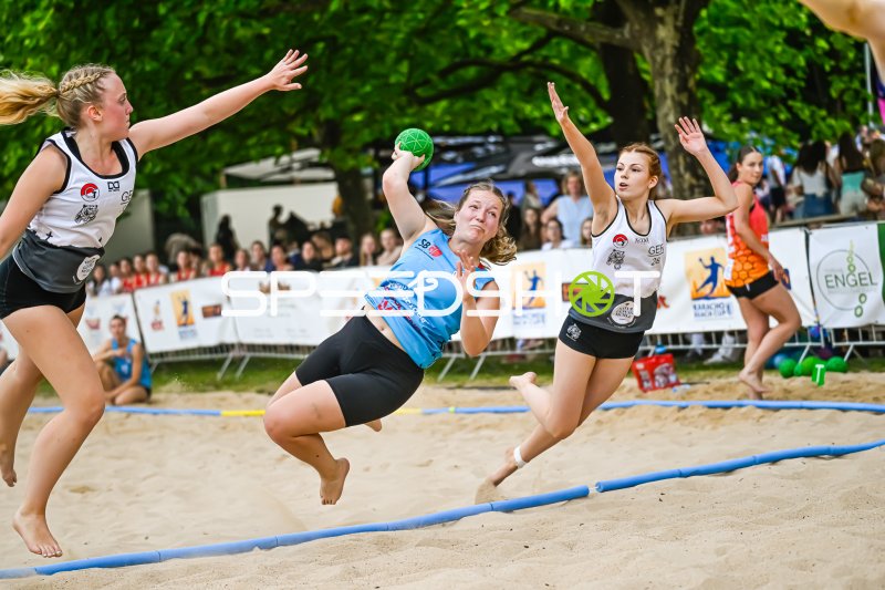 Spielerin (#12) beim Wurfversuch im Beach-Handball-Turnier