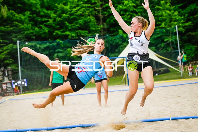Spektakulärer Wurfversuch im Beach-Handball unter Bedrängnis