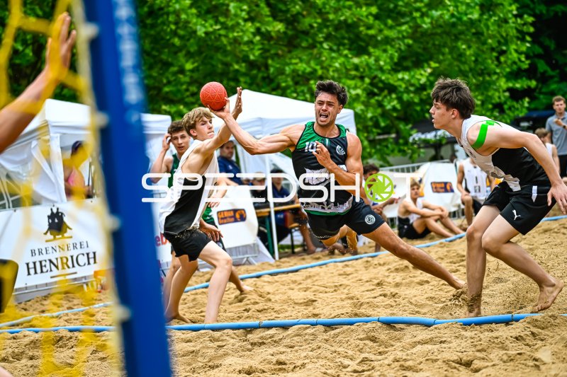 Spieler (#10) mit Wurfversuch beim Beach-Handball-Turnier