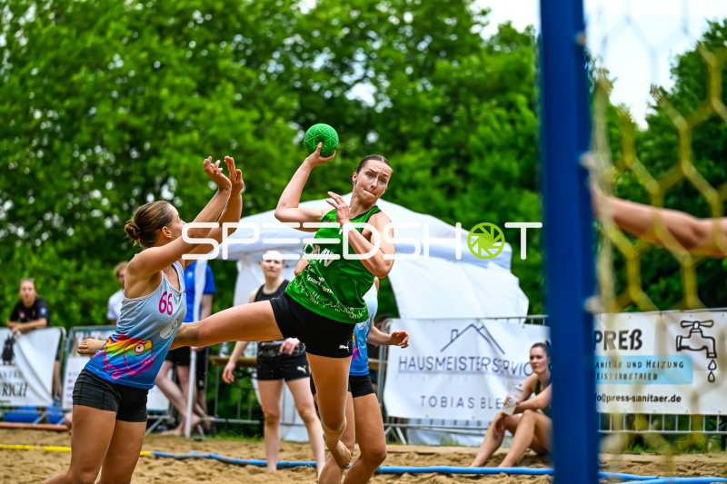 Wurfaktion beim Beach-Handball: Spielerin im grünen Trikot zieht ab