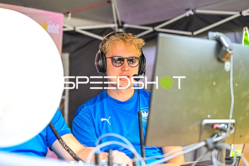 Moderator mit Headset am Kommentatorenpult bei Sportveranstaltung