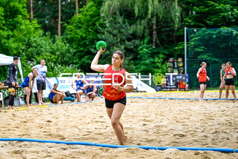 Spielerin (#4) beim Wurfversuch im Beach-Handball-Turnier