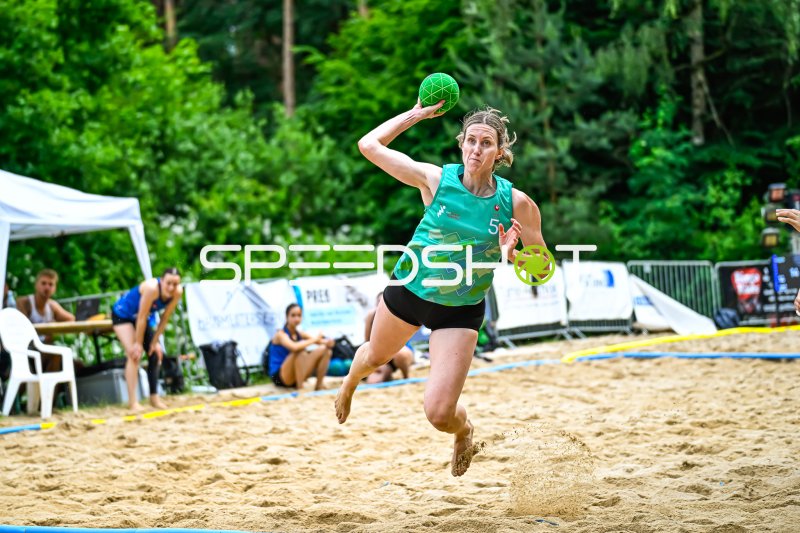 Spielerin (#5) beim Wurfsprung im Beach-Handball
