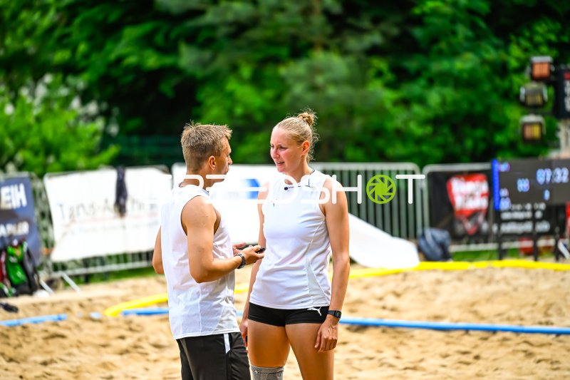 Zwei Athleten im Gespräch auf dem Beachvolleyball-Feld