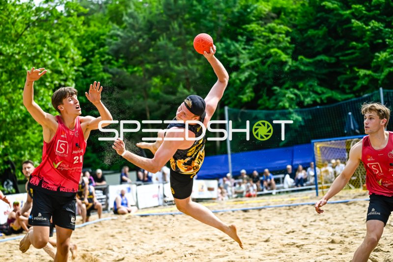 Wurfaktion beim Beach-Handball: Spieler im Sprung gegen Abwehr #21