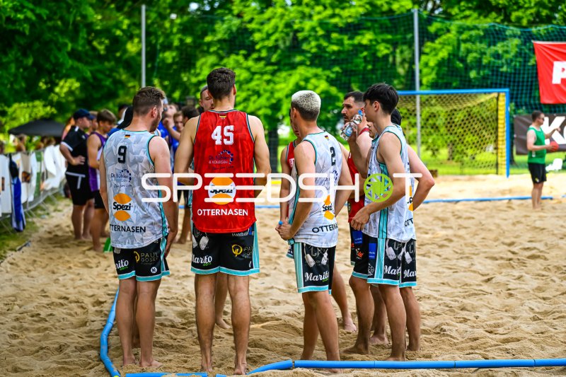 Otternasen-Spieler (#45, #9, #2) bei Teambesprechung im Beach-Handball