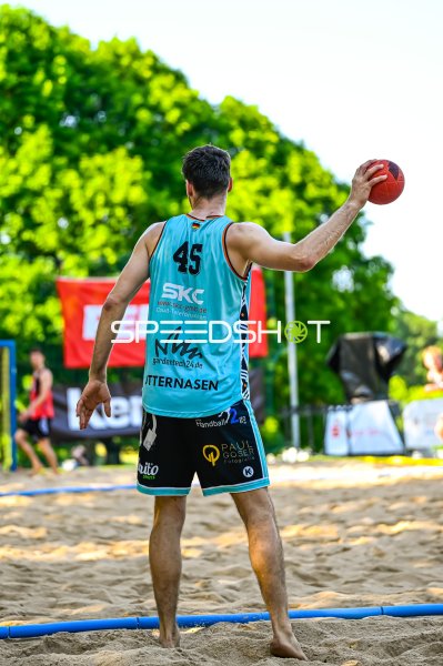 Spieler #45 beim Wurf im Beach-Handball-Spiel