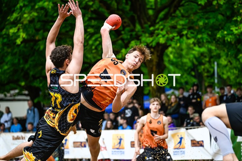 Wurfaktion im Outdoor-Handball: Spieler (#33) im Sprungwurf gegen Abwehr
