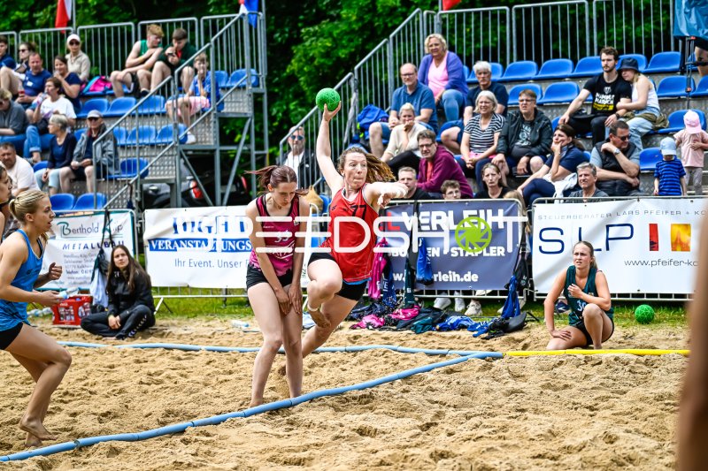 Spielerin (#77) beim Wurf im Beach-Handball-Turnier