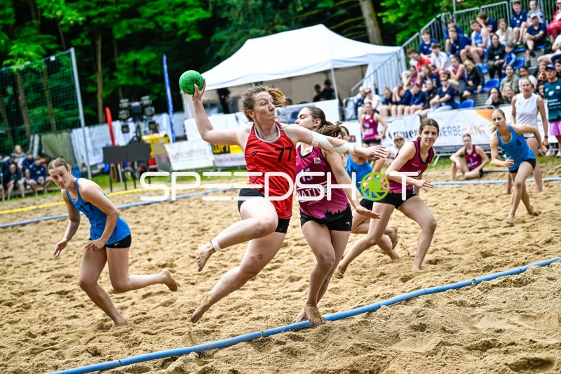 Spielerin (#77; Rotes Team) beim Wurfversuch im Beach-Handball