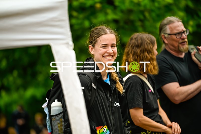 Lächelnde Athletin mit Rucksack bei Outdoor-Veranstaltung