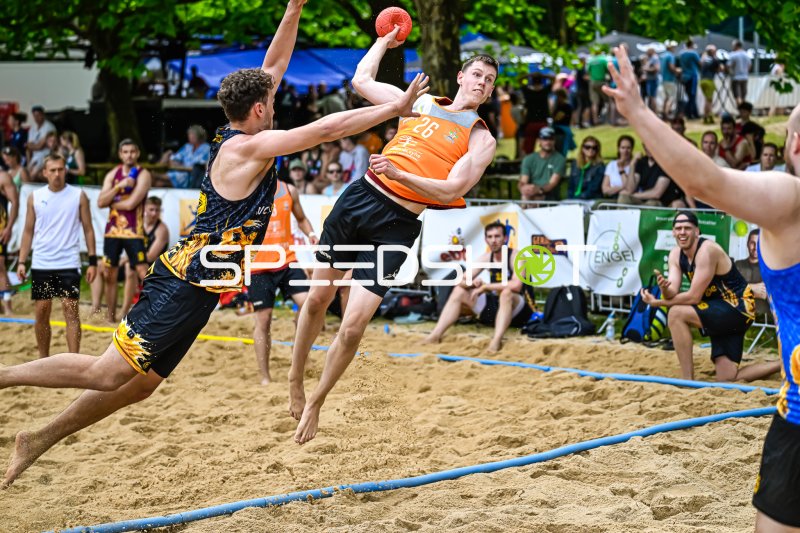Spieler (#26) beim Wurfversuch im Beach-Handball-Turnier