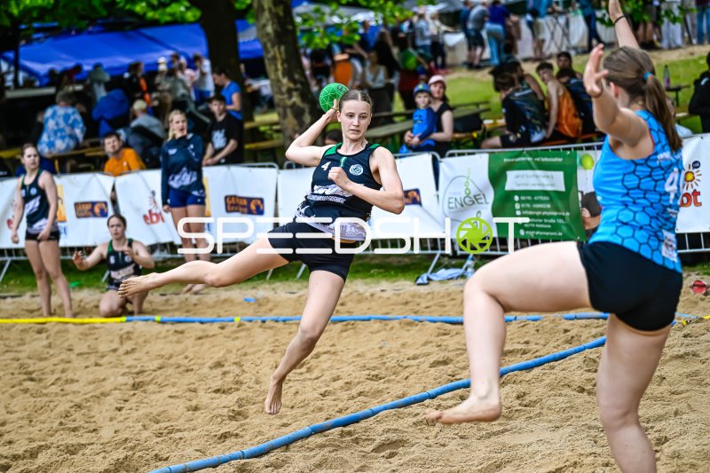 Spielerin (#4) beim Wurfversuch im Beach-Handball-Match