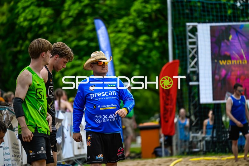 Trainer mit Cowboyhut gibt Anweisungen bei Beach-Handball-Turnier