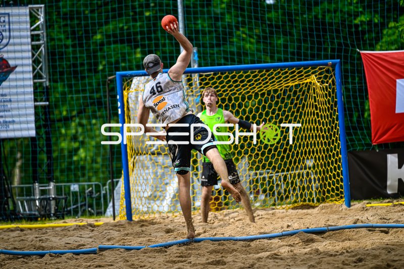 Spieler #46 beim Wurfversuch im Beach-Handball-Match