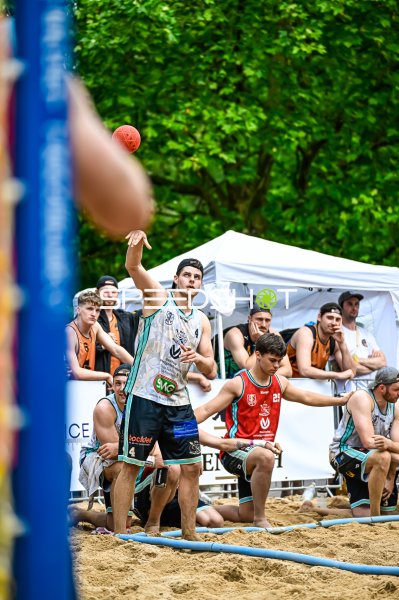 Spieler (#4) beim Wurf im Beach-Handball-Turnier