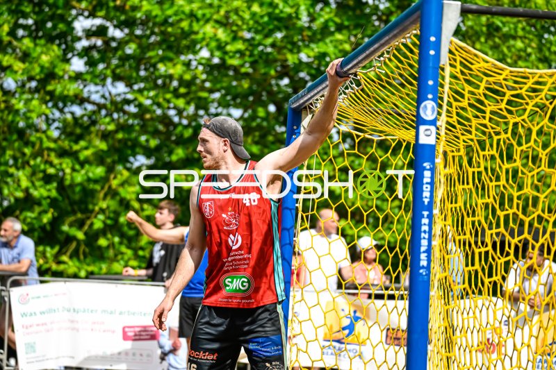 Spieler #46 hält sich am Torpfosten fest beim Beach-Handball