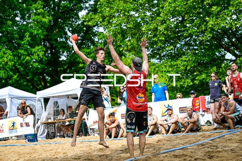 Spieler #21 (Schwarz) springt zum Wurf gegen Abwehrspieler #46 beim German Beach Open